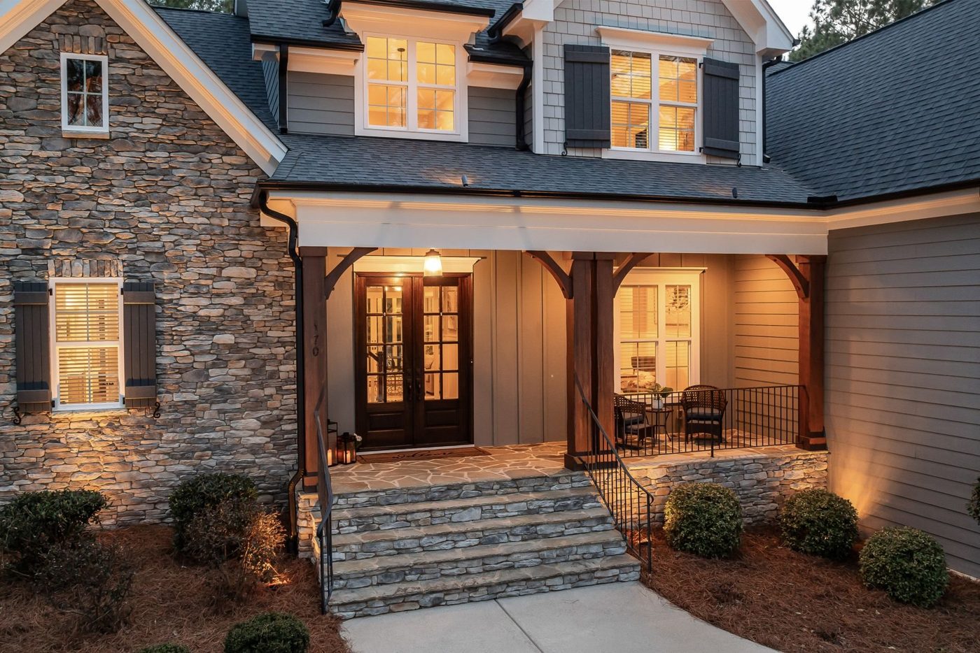 A welcoming house entrance with a lit porch at dusk